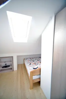 a small bedroom with a bed and a skylight at Fd.Eight Apartment in Belgrade