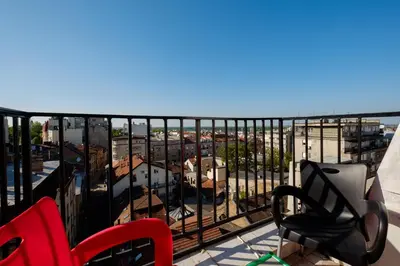 a balcony with two chairs and a view of a city at Apartment 14 in Belgrade