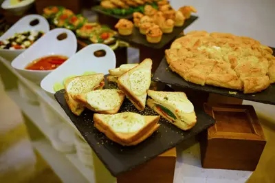 a table with sandwiches and a pie and other foods at Hotel City Savoy in Belgrade
