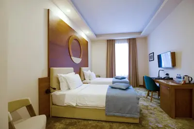 a hotel room with a bed and a desk at Hotel City Savoy in Belgrade