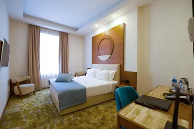 a hotel room with a bed and a desk at Hotel City Savoy in Belgrade