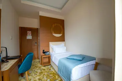 a hotel room with a bed and a desk and a chair at Hotel City Savoy in Belgrade