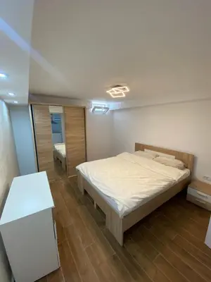 a bedroom with a bed and a table and a mirror at Baron Apartment in Belgrade