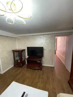 a living room with a flat screen tv and a table at Baron Apartment in Belgrade
