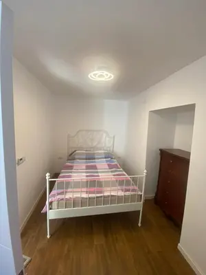 a white bed in a room with a ceiling at Baron Apartment in Belgrade