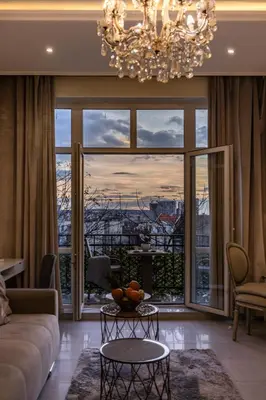 a living room with a chandelier and a large window at Max Luxury Apartments in Belgrade