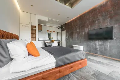 a bedroom with a bed and a wall with a tv at Max Luxury Apartments in Belgrade