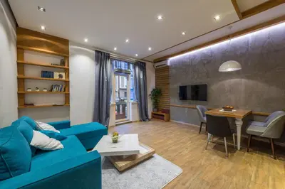a living room with a blue couch and a dining room at Max Luxury Apartments in Belgrade
