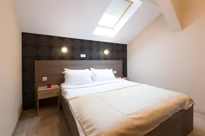 a bedroom with a large white bed with a skylight at Sabor in Belgrade