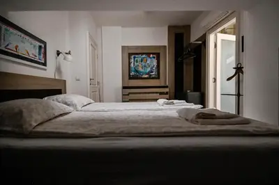 a bedroom with a large bed with two towels on it at Green and Blue Garden Apartments in Belgrade