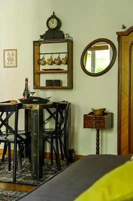 a room with a table and chairs and a clock on the wall at Green and Blue Garden Apartments in Belgrade