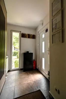 an empty hallway with a door and a window at Green and Blue Garden Apartments in Belgrade