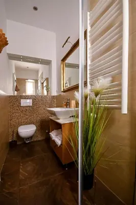 a bathroom with a sink and a toilet and a mirror at Green and Blue Garden Apartments in Belgrade