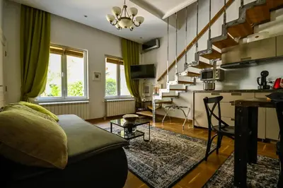 a living room with a couch and a staircase at Green and Blue Garden Apartments in Belgrade