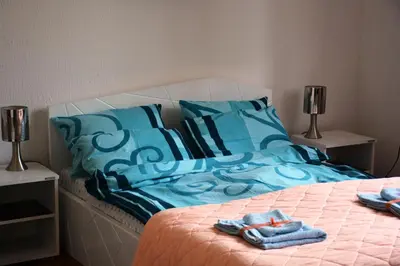 a bed with blue pillows and towels on it at Cozy Downtown Apartment in Belgrade
