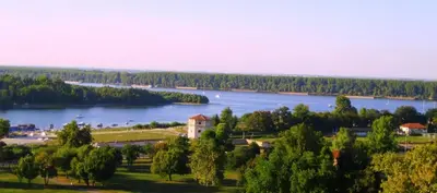 a view of a lake with trees and a building at Cozy Downtown Apartment in Belgrade