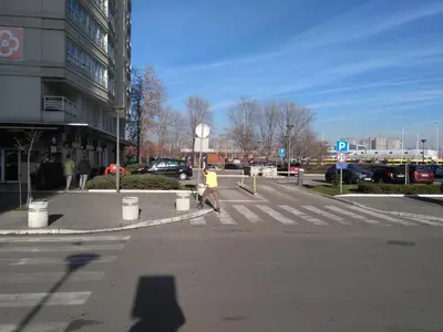 a person walking across a crosswalk in a street at Apartment Tifani Belville in Belgrade