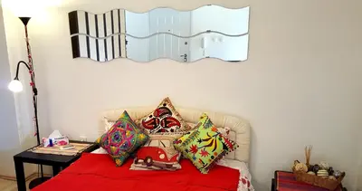 a bedroom with a bed with pillows and a mirror at Apartment Greenfield in Belgrade