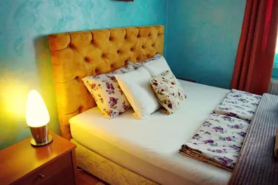a bed with pillows and a lamp on a table at Marilyn Apartments in Smederevo