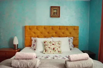 a bedroom with a bed with a blue wall at Marilyn Apartments in Smederevo
