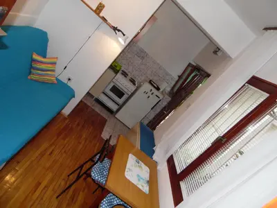 a living room with a blue couch and a window at Studio Kalenic in Belgrade