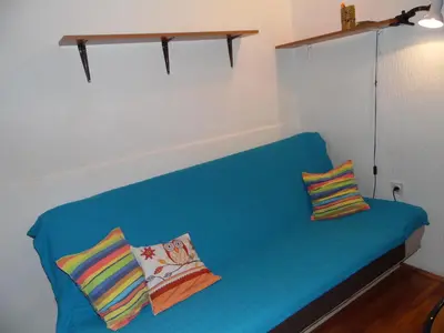 a blue couch with two colorful pillows on it at Studio Kalenic in Belgrade