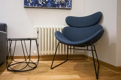 a blue chair sitting in front of a wall at Belgrade CITY CENTER Apartments PARKING 12e - 7 min by walk TERAZIJE in Belgrade