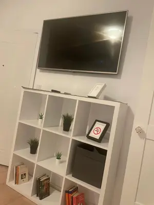 a white book shelf with a tv on a wall at Slavija Square Apartments in Belgrade