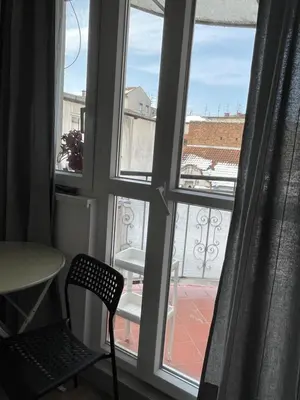 a window with a chair looking out at a balcony at Slavija Square Apartments in Belgrade