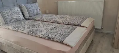a bed with black and white sheets and pillows at Apartment Flora Arandjelovac in Arandjelovac