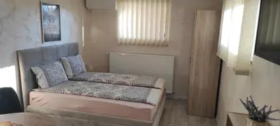 a small bedroom with a bed and a chair at Apartment Flora Arandjelovac in Arandjelovac