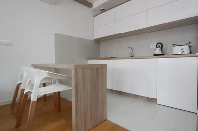 a kitchen with a wooden table and white cabinets at New Belgrade Apartments Magnetic, parking 5 evra dan in Belgrade