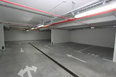 an empty parking garage with white arrows on the floor at New Belgrade Apartments Magnetic, parking 5 evra dan in Belgrade
