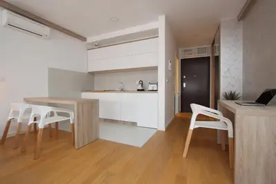 a kitchen with a table and some white cabinets at New Belgrade Apartments Magnetic, parking 5 evra dan in Belgrade