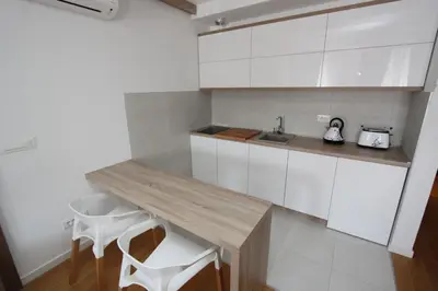 a kitchen with a wooden table and white cabinets at New Belgrade Apartments Magnetic, parking 5 evra dan in Belgrade