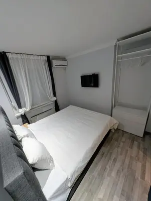 a bedroom with a white bed and a couch at Top Belgrade Apartments in Belgrade