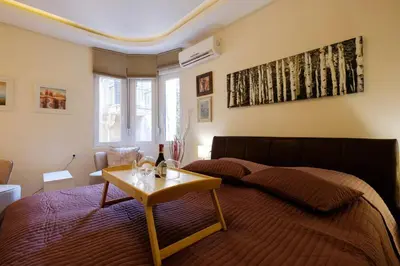a bedroom with a bed and a table with a bottle of wine at Enjoy Belgrade in Belgrade