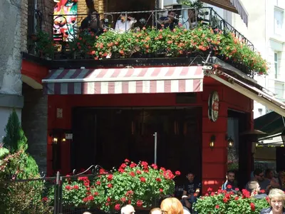 a group of people standing outside of a restaurant with flowers at Enjoy Belgrade in Belgrade