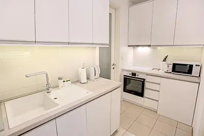 a white kitchen with a sink and a microwave at Belville Luxury Apartment in Belgrade