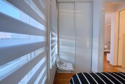 a room with a chair next to a wall at Belville Luxury Apartment in Belgrade