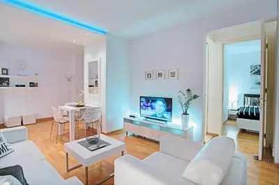 a living room with a white couch and a tv at Belville Luxury Apartment in Belgrade