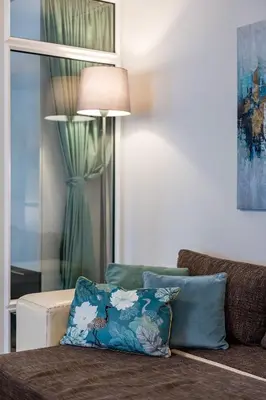 a couch with a pillow on it with a lamp at French House in Belgrade
