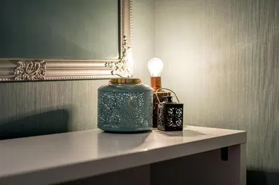 a table with a blue candle and a lamp on it at French House in Belgrade