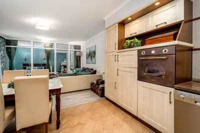 a kitchen with an oven and a table and a living room at French House in Belgrade