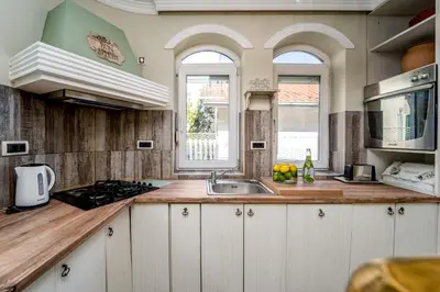 a kitchen with white cabinets and a sink at French House in Belgrade