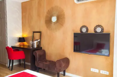 a living room with a tv and a chair and a table at Gentleman Dog Apartment in Belgrade