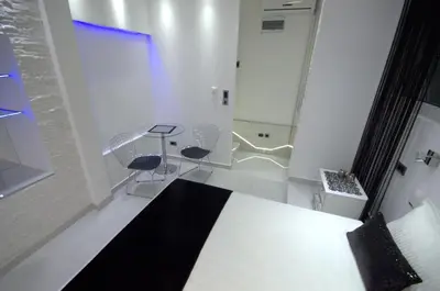 a bedroom with a bed and two chairs and a table at Monroe Apartment in Belgrade