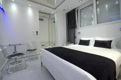 a bedroom with a bed and a table and chairs at Monroe Apartment in Belgrade