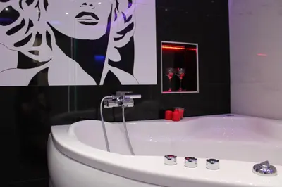a bathroom with a tub with a picture of a woman at Monroe Apartment in Belgrade