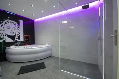 a bathroom with a tub and a glass shower at Monroe Apartment in Belgrade